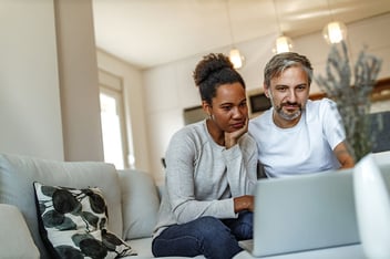 A couple at a laptop researches the differences between a Roth IRA vs. a traditional IRA.