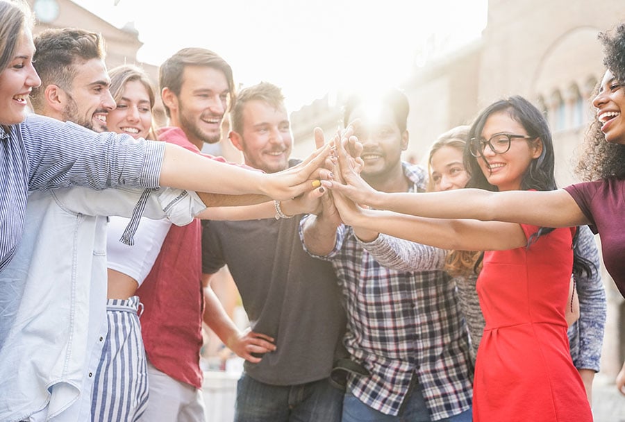 a group of young credit union members give each other a big high five