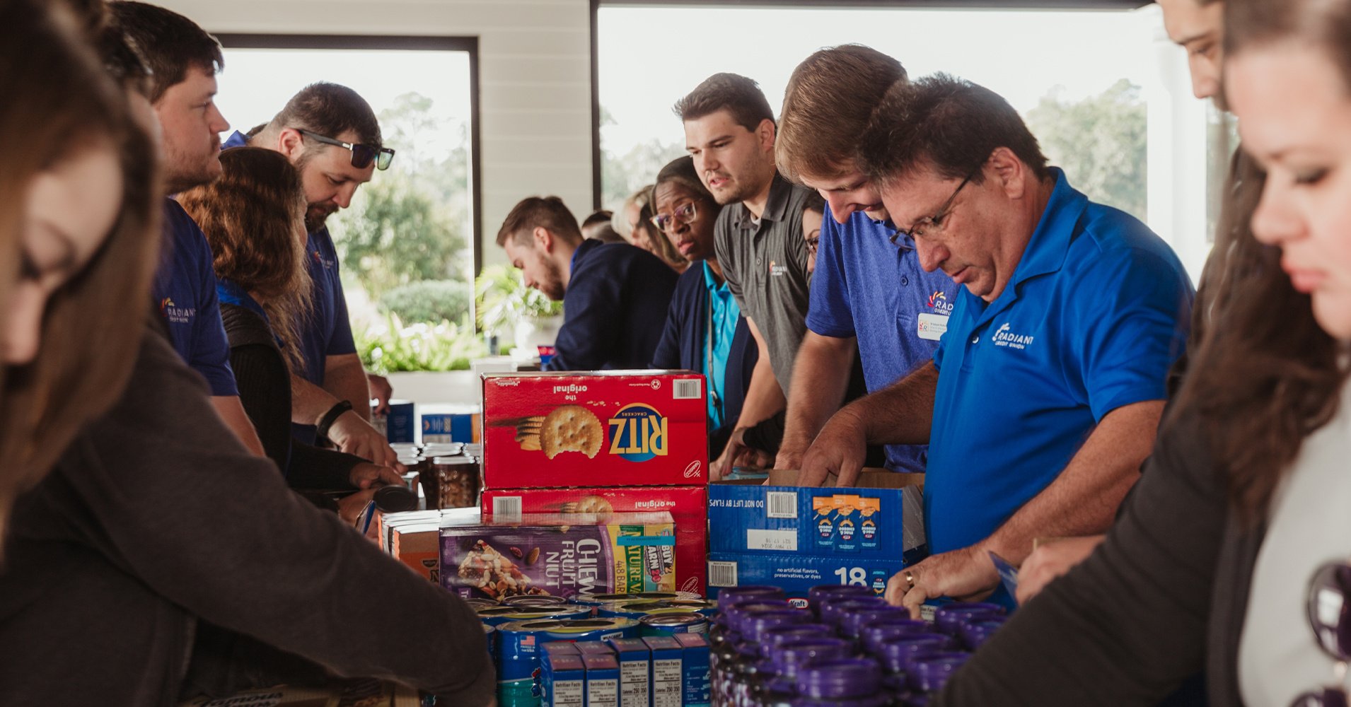 Members of Team Radiant help package up care packages for needy families in fall of 2023.