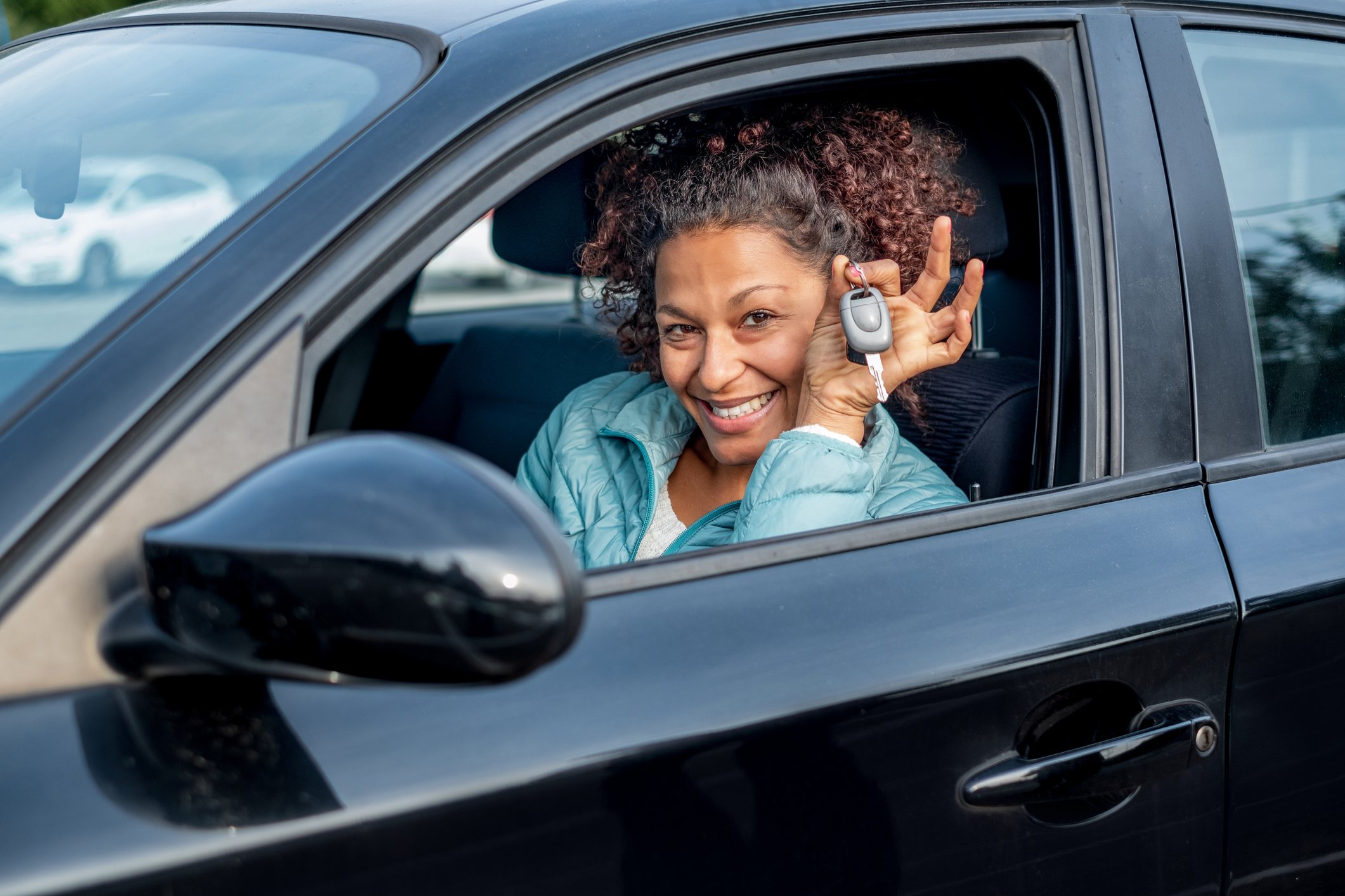 Image of woman holding cars keys inside a new car.