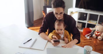 A woman with her baby sitting in her lap reviews research she did on how to save money for college.