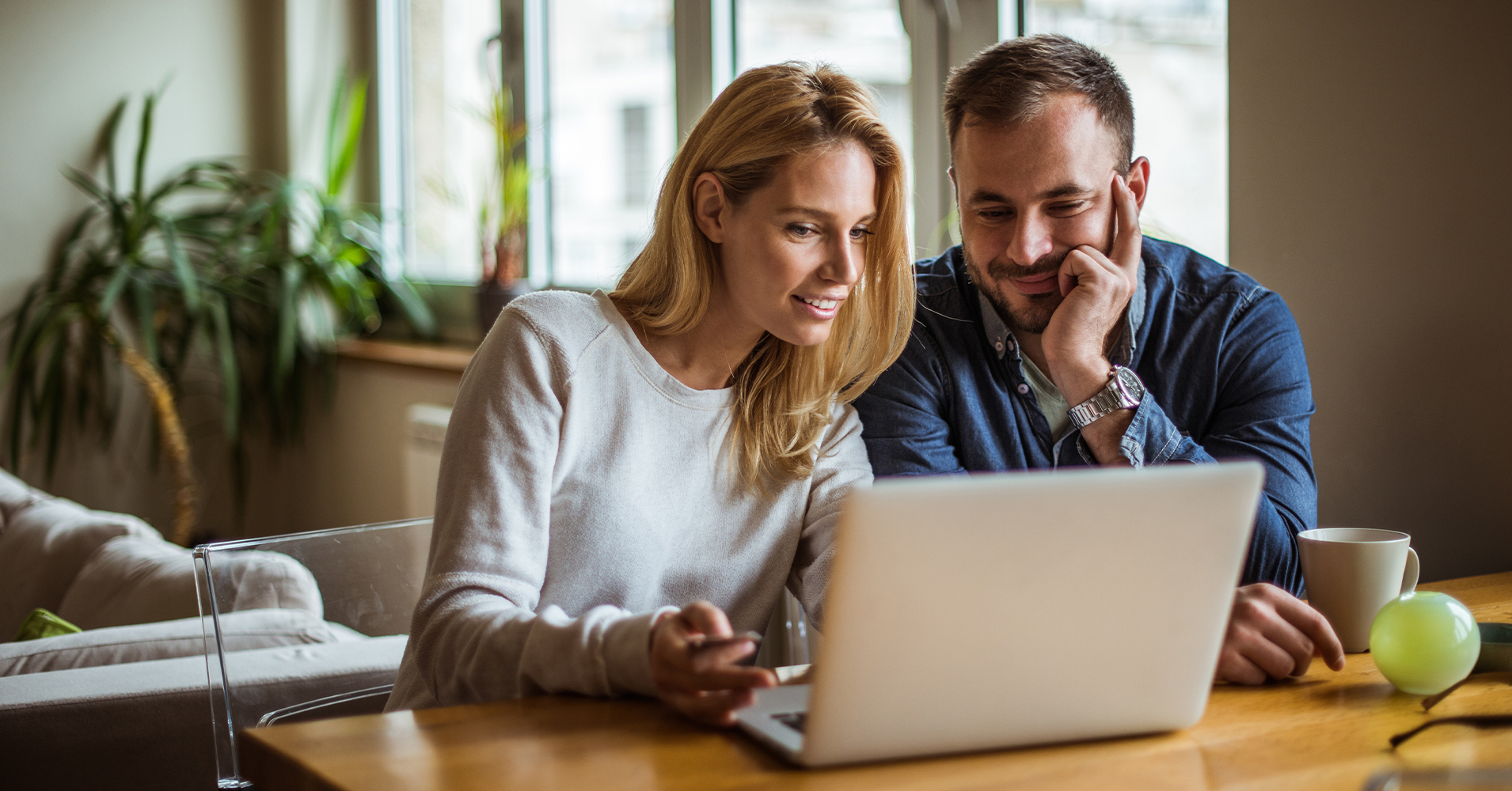 couple looking happy chatting at a laptop